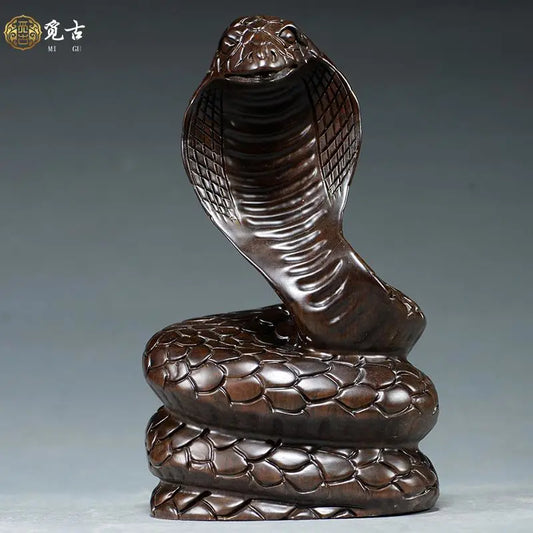 Solid ebony wood carving of the snake among the twelve Chinese zodiac animals (cobra) ornaments. They can attract wealth and are used for home and office decoration as well as feng shui purposes. They are handicraft items made of mahogany.