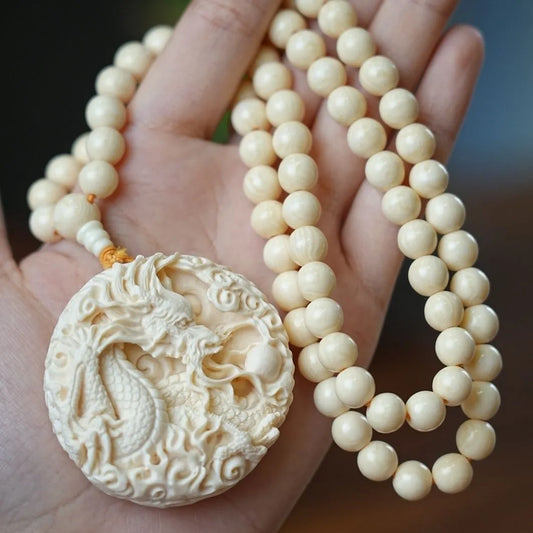 Hand - carved Double - sided Mammoth Ivory Pendant with Dragon and Phoenix Patterns. It can be used as a hanging ornament, a necklace pendant, a Buddhist bead pendant, or a trendy sweater chain.